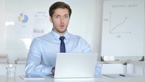 Surprised Young Businessman in Office Looking at Camera, Shocked