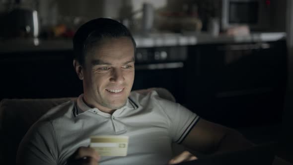 Closeup Cheerful Man Making Yes Gesture in Front of Laptop Screen at Dark Office