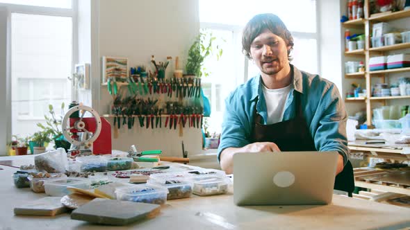 Happy man conducts training online using a laptop in the studio