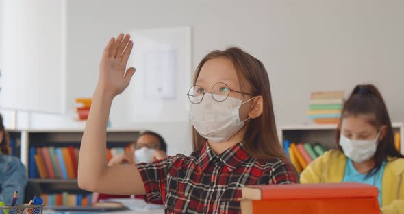 Kid Wearing Face Mask and Raising Hand in School Class