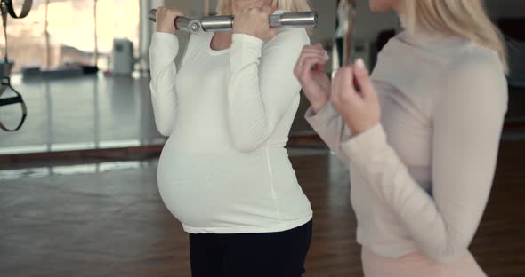 Pregnant Women Doing Fitness Exercise with Dumbbells