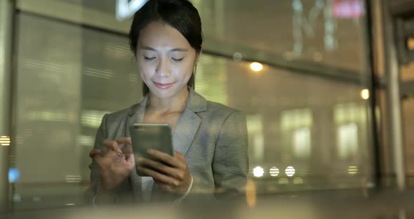 Business woman use of mobile phone at night 