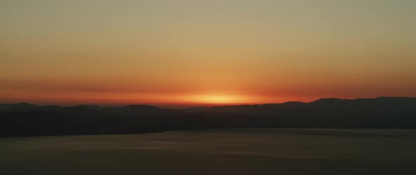 Beautiful landscape with sunset over the big lake and the mountains. Tilting down to up shot. 