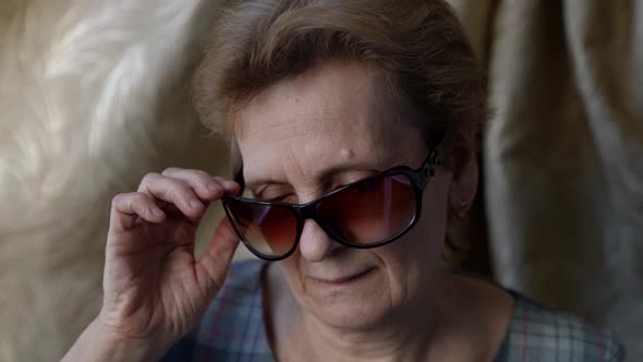 Portrait of an Elderly Woman in Dark Glasses Then She Takes Them Off