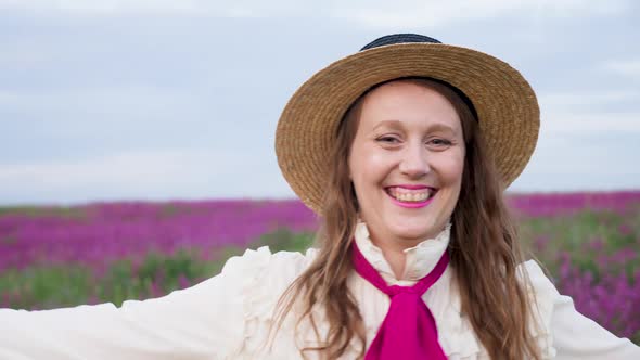 Girl in a Blue Dress with a White Blouse and a Straw Hat Walks Along