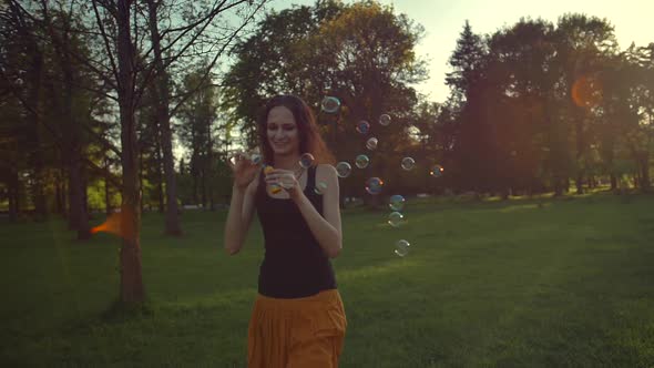 Young Woman Playing with Soap Bubbles, Outdoor Having Fun. Sunflare.