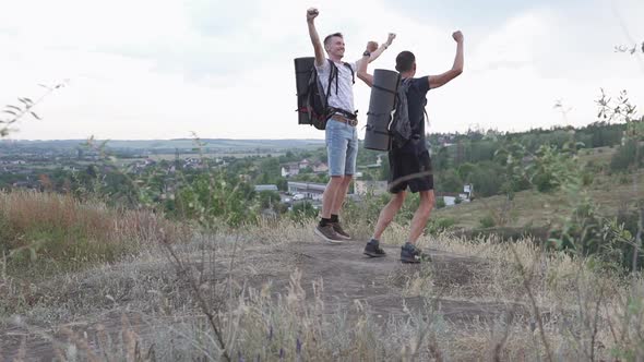 The two climbers on the top of the mountain are very happy.