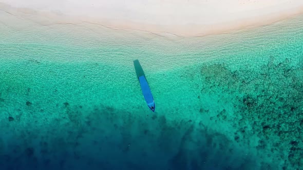 Coast and fishing boat as a background from top view. Turquoise water background from top drone.