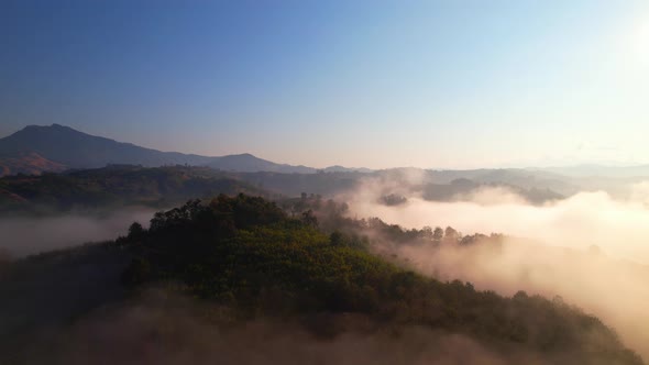 clouds above the valley and the mountains in the background. 4K Aerial video