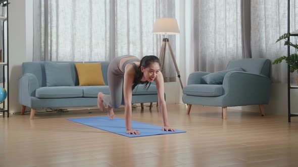 Asian Female In Sports Clothes Doing Cardio High Knees And Core Strengthening Exercises