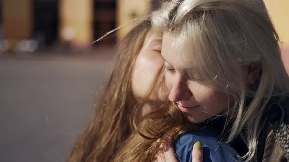 Portrait of Two Lesbian Girls in Love Sit on Motorcycle Hugging and Stroking Each Other Close Up