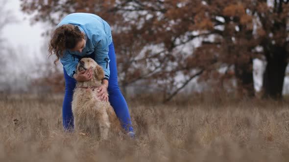 Joyful Young Female Petting Her Lovely Dog Outdoors