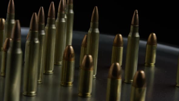 Cinematic rotating shot of bullets on a metallic surface 