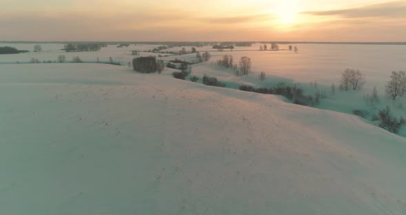 Aerial View of Cold Arctic Field Landscape Trees with Frost Snow Ice River and Sun Rays Over Horizon