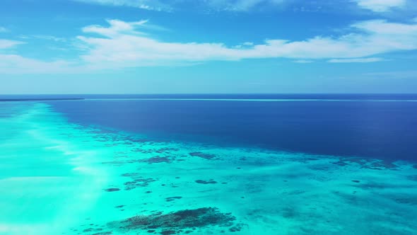 Luxury flying travel shot of a white sandy paradise beach and blue water background in high resoluti