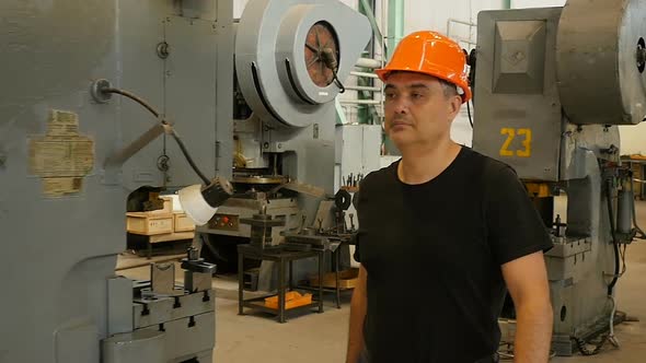 Professional Factory Worker In Hard Hat Walking Through Heavy Industrial Manufacturing Facility