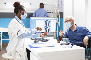 Doctor shows radiograph to elderly man