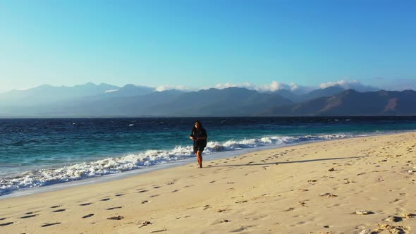 Girl tans on marine coastline beach journey by turquoise lagoon with white sand background of the Ma