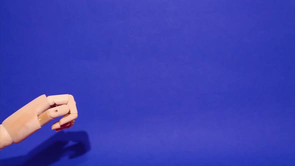 Wooden Hands on a Blue Background Next to Red Gift Boxes