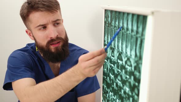 Physiotherapist Shows Patient an Xray Image of Skeleton of Bones