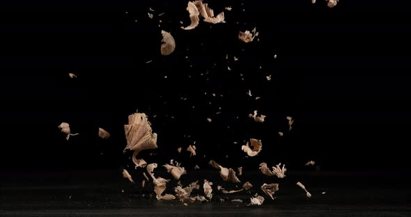 Wood Chips Falling against Black Background, Slow Motion 4K