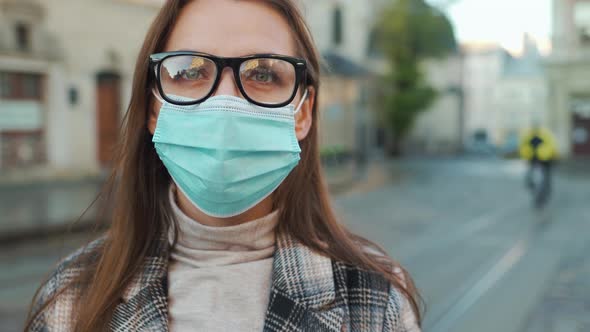 Pandemic Protection of the Covid-19 Coronavirus. Portrait of a Woman in a Coat, Glasses and a