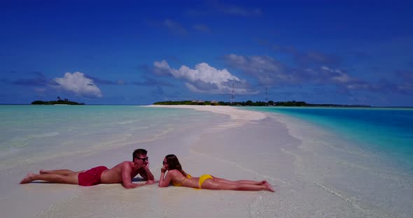 Beautiful man and woman in love dating on vacation have fun on beach on clean white sand 4K backgrou