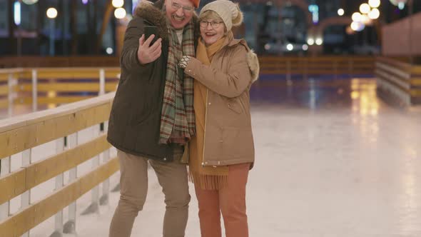 Senior Couple Taking Selfie On Ice Rink