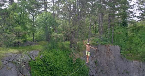 A man tries to balance while slacklining on a tightrope