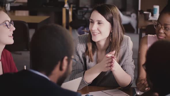 Happy Friendly Businesswoman Listening To Her Colleague at Multiethnic Office Board Meeting