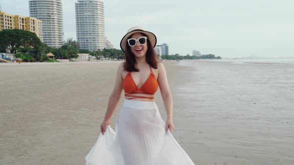 cheerful woman in bikini walking on the sea beach