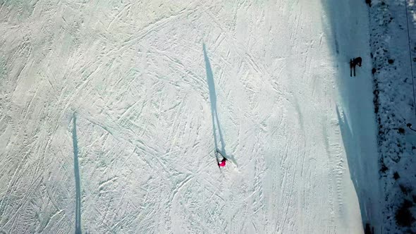 Aerial top view of skiers going down slope in Topolita Snow Summit, Transylvania Romania.