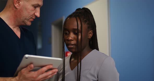 A Doctor Shows His Colleague Something on a Tablet Screen