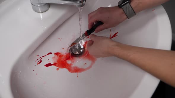 Murder knife smeared with blood being washed in a sink in slow motion