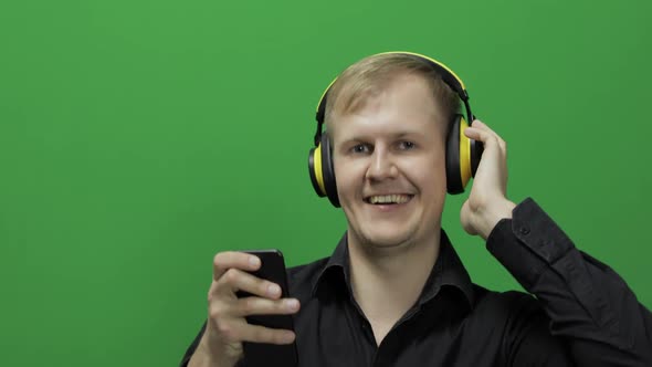Guy Listens To Music in Wireless Yellow Headphones and Dances. Chroma Key