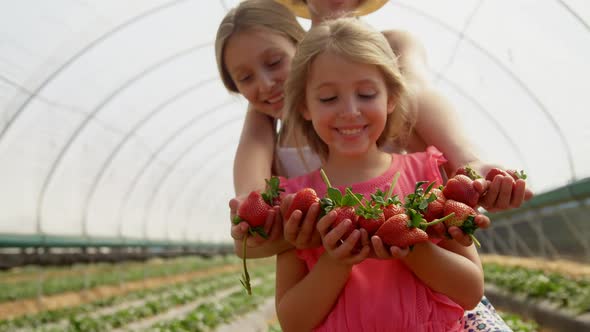 Girls holding strawberries in the farm 4k