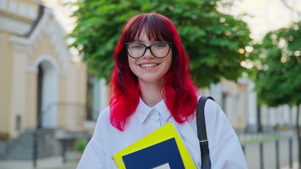 Portrait of Teenage Female Student with Books Backpack Outdoors on City Street