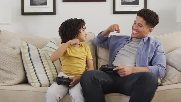 Happy biracial man and his son playing video games