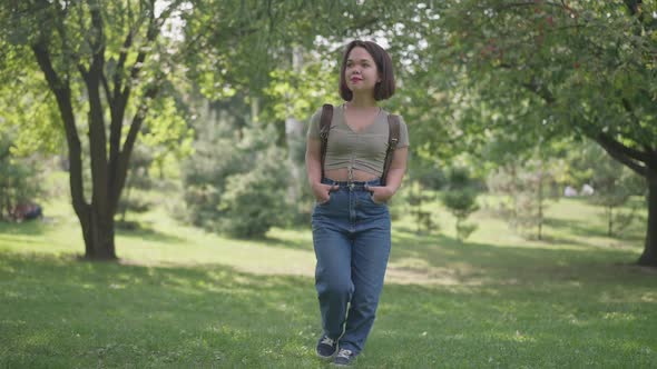 Wide Shot Happy Smiling Young Woman with Dwarfism Walking in Sunny Forest in Slow Motion