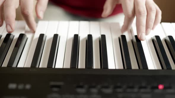 Close up of woman's hand playing the electric piano.