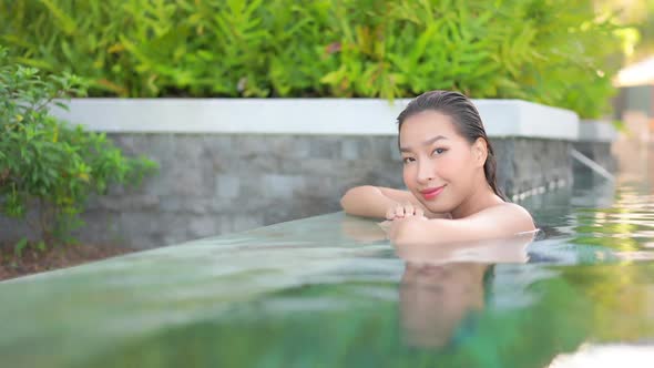 Young asian woman enjoy around outdoor swimming pool for leisure