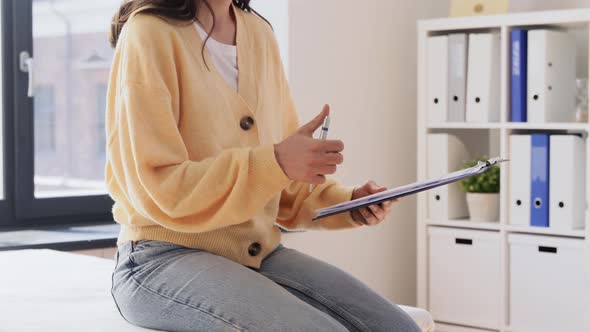 Female Patient Giving Papers to Doctor at Clinic