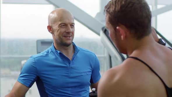 Man Talking to Trainer after Workout in Gym