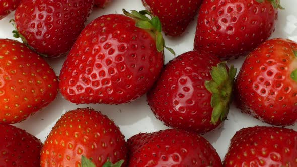 Juicy ripe exotic strawberry rotates on a white background 360. Eco fruits and berries summer.