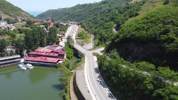 Aerial view rising and retreating, showing country road, lake and restaurant