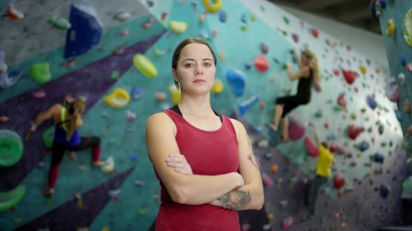 Confident Female Climbing Coach Posing at Indoor Gym