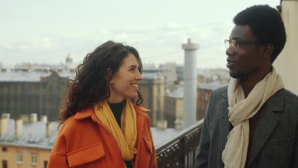 Multiethnic Man and Woman Walking on Rooftop Terrace and Speaking