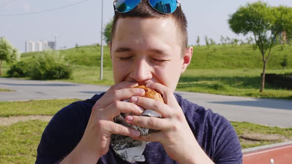 A Man Biting Hamburger with Great Appetite