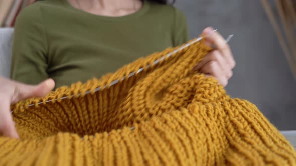 Closeup of Female Hands Knitting a Warm Sweater Knitting with Needles and Woolen Thread Hobby and