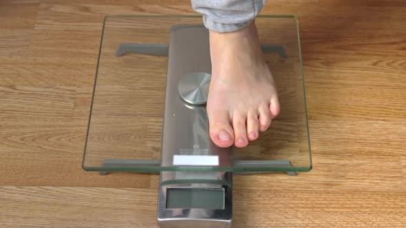 Women's Feet Stand on the Scales and Check Their Kilograms Top View
